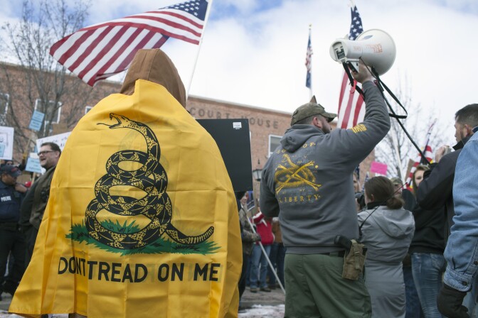 BURNS, OR  - FEBRUARY 1: An anti-government protester wrapped in a Gasden flag stands outside the Harney County Courthouse on February 1, 2016 in Burns, Oregon.  Approximately 300 people gathered in support of law enforcement, while 200 people protesting the government were also in attendance (Photo by Matt Mills McKnight/Getty Images)