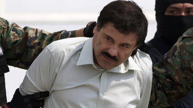 Joaquin "El Chapo" Guzman is escorted to a helicopter in handcuffs by Mexican navy marines at a navy hanger in Mexico City.