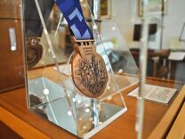 Medals and torches are shown in display through out the Sports Library in LA84 Foundation. This medal is from the 2002 Winter Olympic games held in Salt Lake City, Utah.