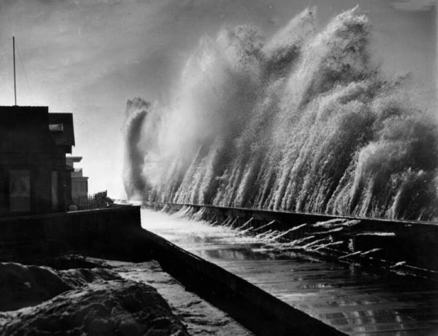 Black and white photo of waves over six feet tall crashing against a sea wall in Belmont Shores in Long Beach.