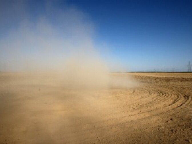 Dust billows as a farmer plows a dry field near Buttonwillow, California. Central Valley farmers and farm workers are suffering through the third year of the worsening California drought with extreme water shortages and job losses.