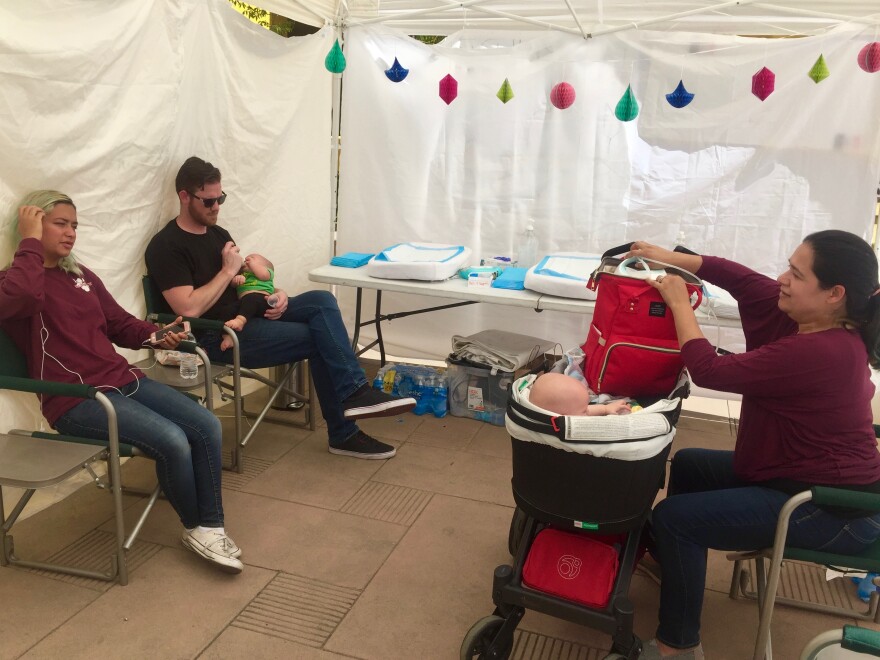 (From left to right) Madeleine Cox, Micah Bennett and Ashley Bennett take a break in the family tent to feed and change seven-month old twins Eleanor and Benjamin during the March for Science in L.A. on April 14, 2018.