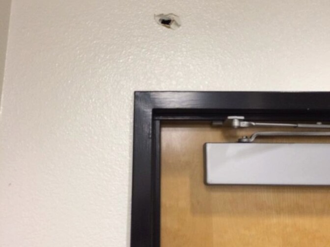 A bullet hole above the door of a room where the Olympic Park Neighborhood Council was holding a meeting when a shooting took place in the lobby of the LAPD West Traffic Division Station on April 7, 2014. No one inside the room was hurt. People inside the room say the bullet caused debris from the wall to fall on some members.