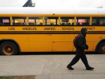 A student on his way to school walks past a Los Angeles Unified School District (LAUSD) school, in Los Angeles, California on February 13, 2009.