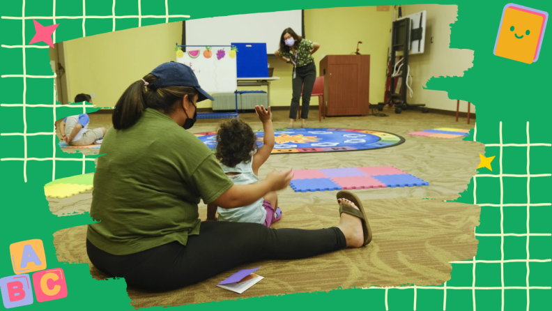 An adult in a green shirt works one-on-one with a young child with curly hair on the classroom floor. Another adult stands in the background near a whiteboard. The early childhood classroom features colorful carpets, foam mats, and educational materials. The image has a decorative green border with alphabet blocks and educational icons.
