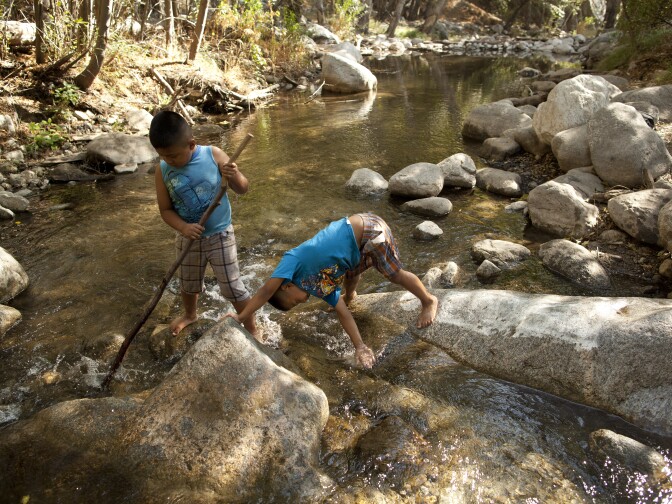 Angel Torres, 7, and his brother, Kevin, 6, play in a river in the San Gabriel Mountains. President Obama designated part of the area in the Los Angeles National Forest a national monument.