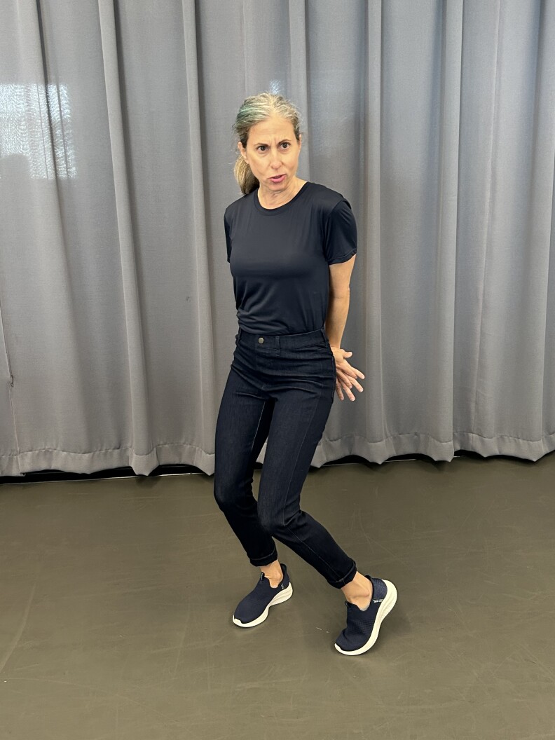 A woman in all black rehearsing for a play