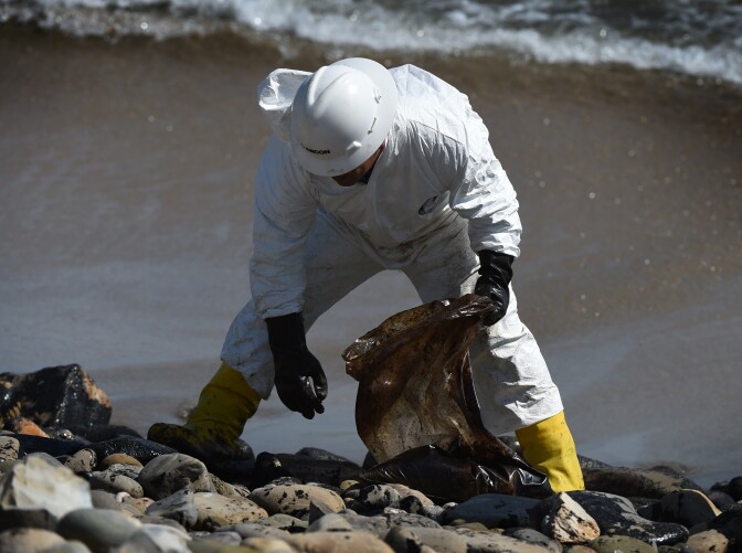 A worker cleans oil from the rocks and beach at Refugio State Beach in Goleta, California, May 22, 2015. The oil company behind a crude spill on the California coast vowed to do the "right thing" to clear up the mess, even as reports emerged of past leaks involving its pipelines. Plains All American Pipeline made the pledge as it said nearly 8,000 gallons of oil had been scooped up, out of some 21,000 gallons believed to have flooded into the ocean near Santa Barbara, northwest of Los Angeles. 