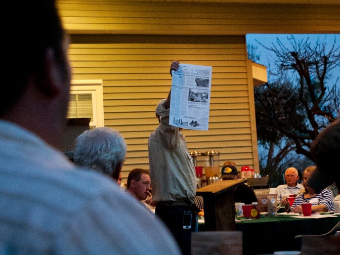 Mike Mulligan, who hosted a beekeeper's dinner on Friday, March 1 at his home in Shafter, Calif., holds up a collection of articles in the Bakersfield Californian, that he printed for all his guests.