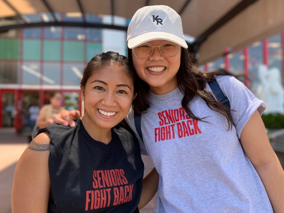 Epidemiologist Tina Koo, right, has her arm around social media coordinator Alyssa San Agustin outside the Asian Garden Mall in Westminster. Both are weaing shirts that read: "Seniors Fight Back"