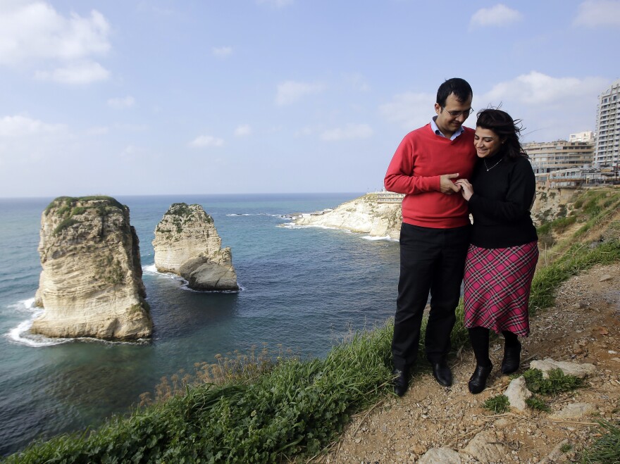 Kholoud Succariyeh (right) and Nidal Darwish, who got married in defiance of Lebanon's ban on civil unions, walk past Beirut's landmark Pigeon Rock in 2013.