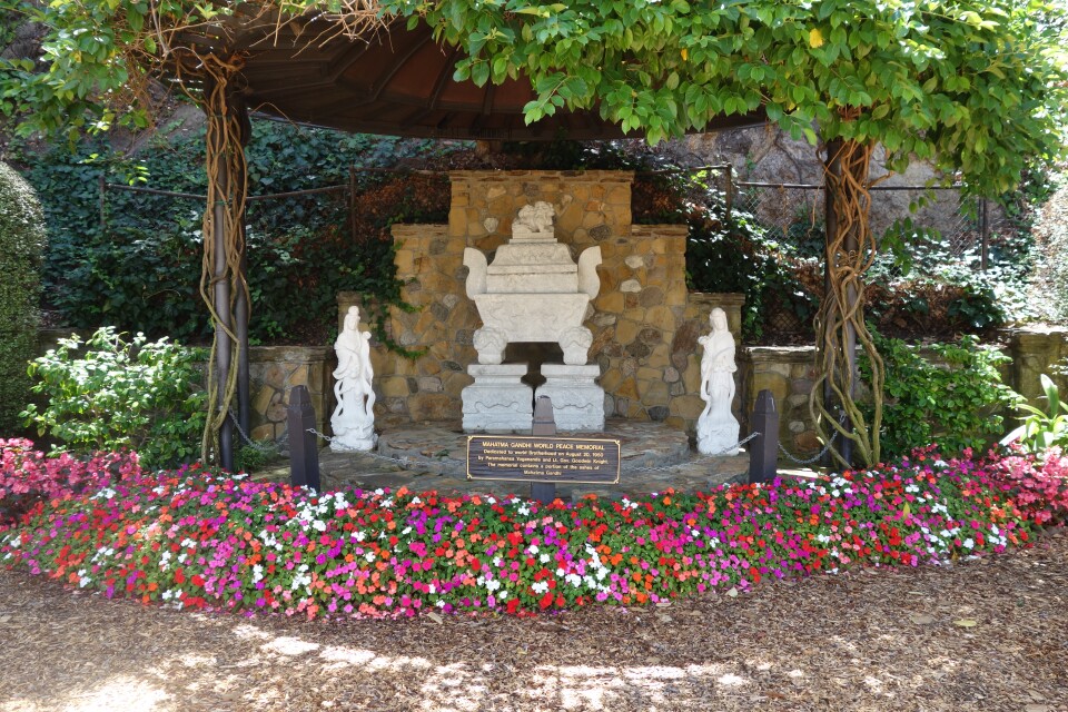 A shrine surrounded by multi-colored flowers.