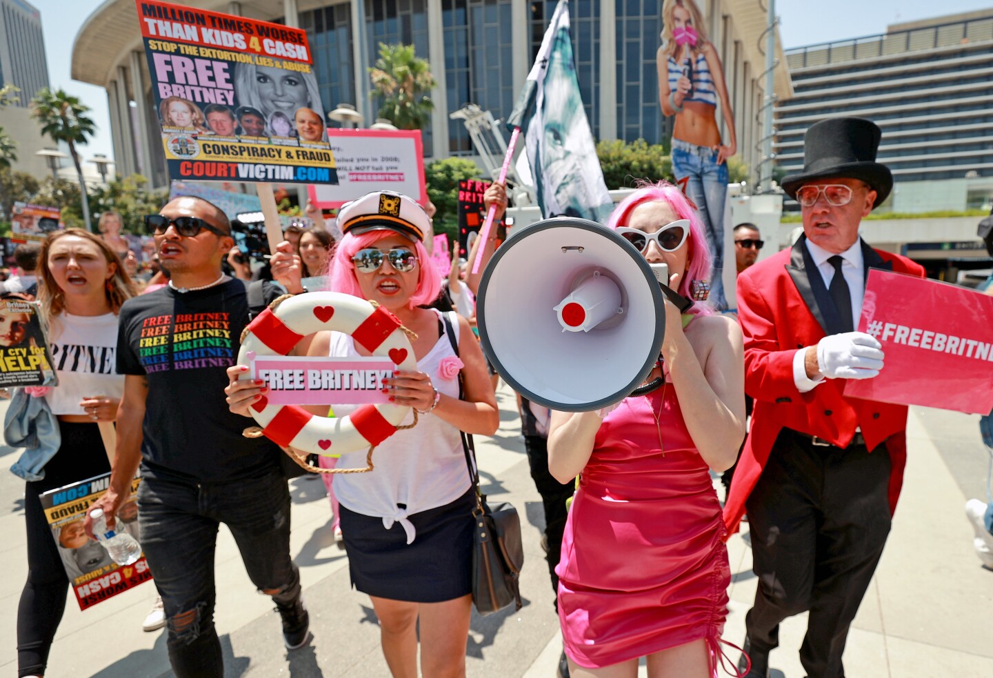Britney Spears fans stand outside during a protest, holding signs reading "Free Britney."