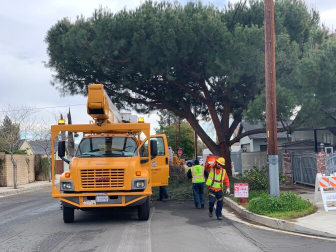 City workers trim and clear tree branches in a residential neighborhood in Canoga Park.