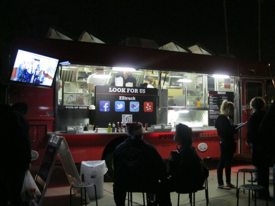 Customers sit near the ZZ Truck during a stop at a food truck event in Harbor City.