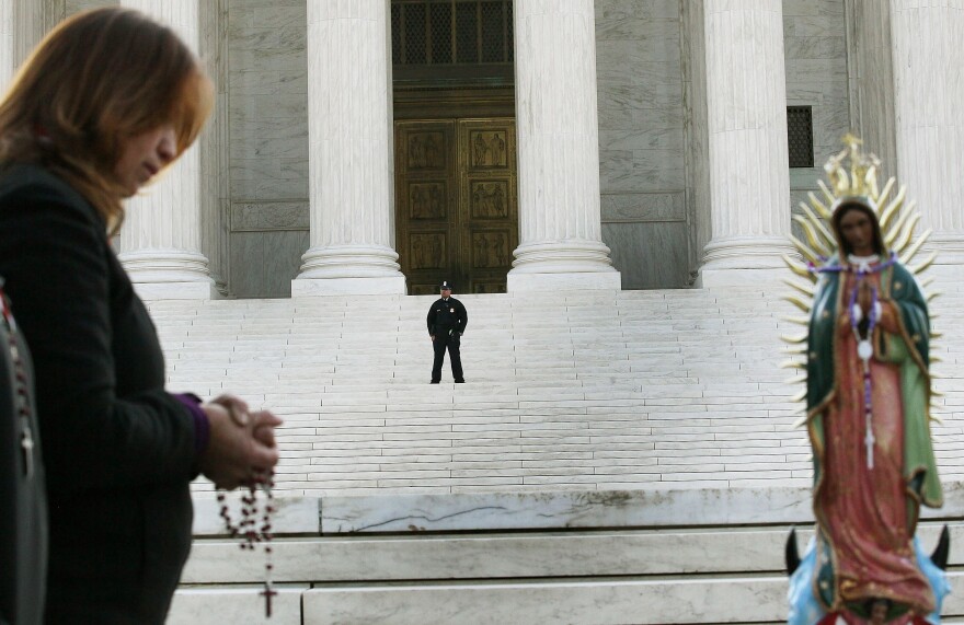 A person prays during a protest in front of the U.S. Supreme Court, on April 25, 2012 in Washington, DC.