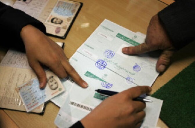 An Iranian man fingerprints his ballot paper before casting his vote at a polling station in Tehran on March 14, 2008.