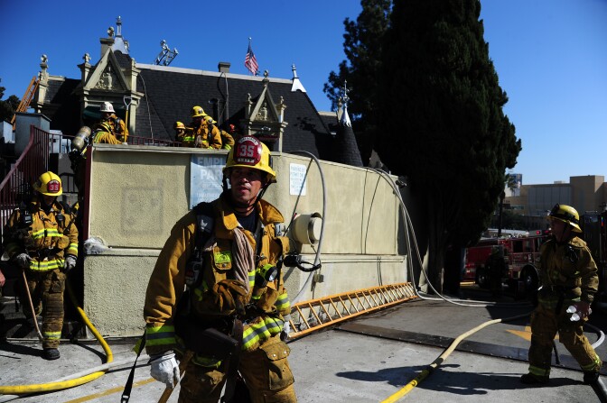 Firefighters work at the Magic Castle in Hollywood, California October 31, 2011. An attic fire broke out at the Magic Castle but firefighters doused the flames and no one was hurt.  The cause of the blaze was under investigation.  The Magic Castle is the private clubhouse for the Academy of Magical Arts Inc., according to the organization's website.   AFP PHOTO / Robyn Beck (Photo credit should read ROBYN BECK/AFP/Getty Images)