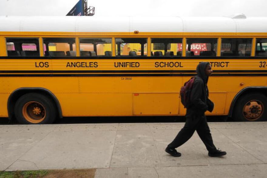  A student walks past a LAUSD school bus.