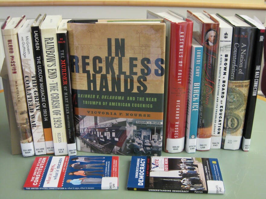 A row of books with "In Reckless Hands" sitting center.