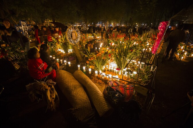 A woman attends to the grave of a loved one on the eve of the Day of the Dead at the cemetery of Tzintzuntzan in Patzcuaro, Michoacan, Mexico on November 1, 2016.