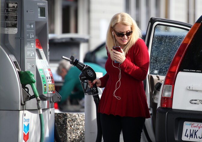 File: A customer prepares to pump gasoline into her vehicle at a Chevron gas station on Feb. 9, 2015 in San Rafael, California.