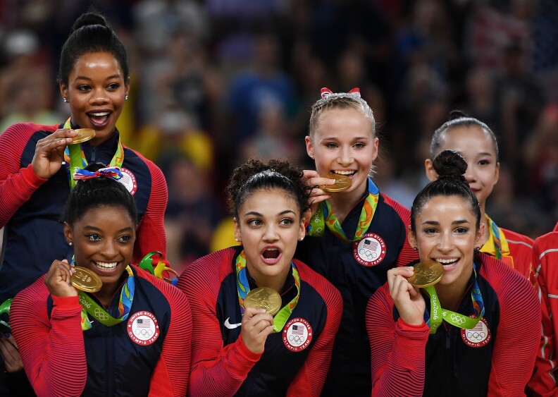 RIO DE JANEIRO, BRAZIL - AUGUST 09:  (L to R) Gold Medalists Gabrielle Douglas, Simone Biles, Lauren Hernandez, Madison Kocian and Alexandra Raisman of the United States pose for photographs on the podium at the medal ceremony for the Artistic Gymnastics Women's Team on Day 4 of the Rio 2016 Olympic Games at the Rio Olympic Arena on August 9, 2016 in Rio de Janeiro, Brazil.  (Photo by Laurence Griffiths/Getty Images)