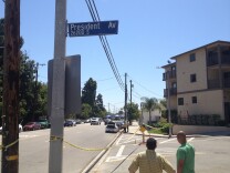 Two onlookers stare south on Anaheim Street in Harbor City Saturday, May 3, 2014 as LAPD investigators continue gathering evidence from the scene of a traffic collision that killed one officer.