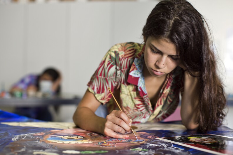 Zelia Corbia, 18, of Hollywood paints a photograph taken during a body modification portrait assignment at CalArt's Community Arts Partnership. The program is free to kids ages six through 18.