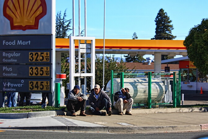 Day laborers sit in front of a Shell gas station in Arizona.