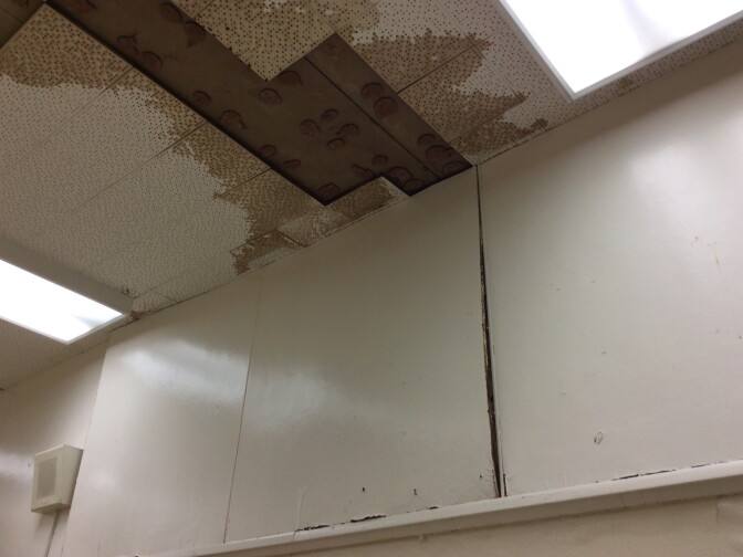 An inspector's photo shows missing tiles and water damage in the ceiling of a classroom at Inglewood High School.
