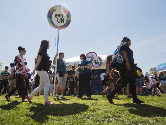 Concert attendees walk past information stands during the 2015 Earth Day concert in Washington, DC on April 18, 2015.