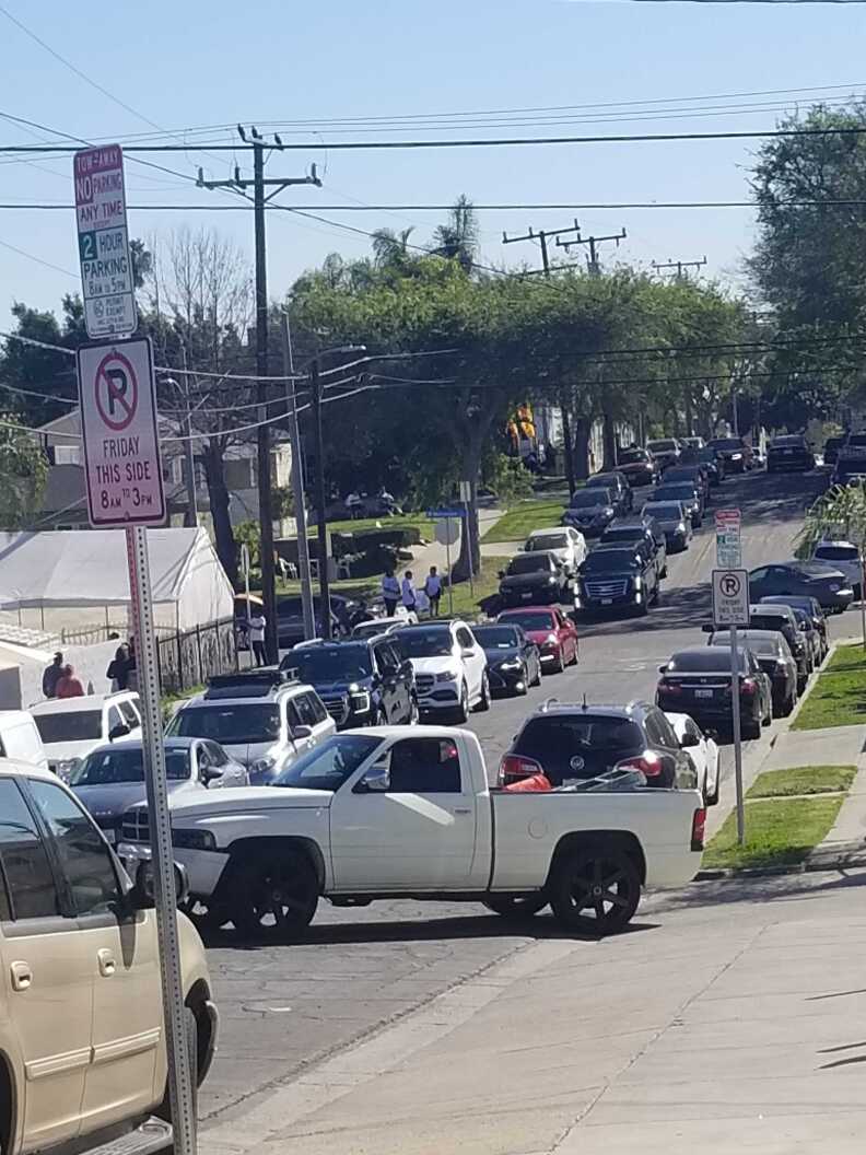A long line of cars navigates a street heading toward SoFi Stadium