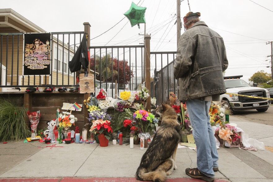 A man looks at a makeshift memorial near the site of a warehouse fire that has claimed the lives of at least thirty-six people on December 5, 2016 in Oakland, California. The fire took place during a musical event late Friday night.