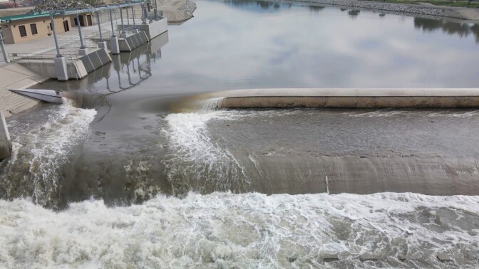 An inflatable dam with water running over it.