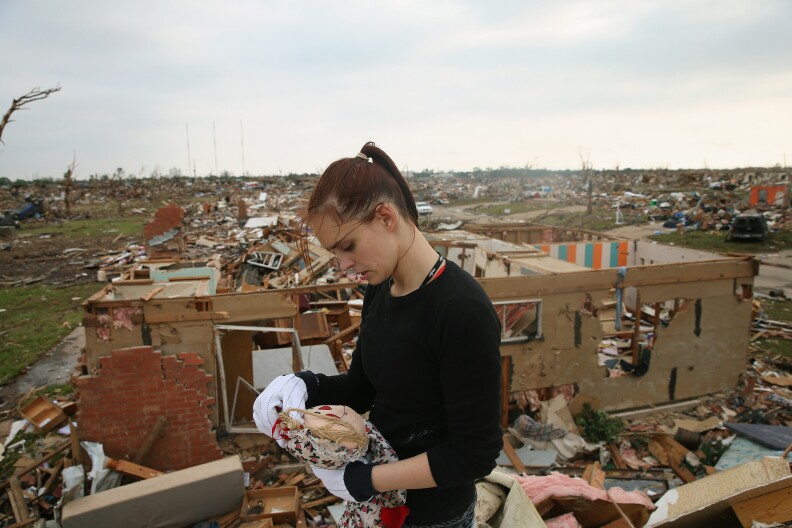Sabrina Mitchell recovers a stuffed doll as she searches for belongings in what was the second floor bedroom of her home which was destroyed by a tornado on May 24, 2013 in Moore, Oklahoma. A two-mile wide EF5 tornado touched down in Moore May 20 killing at least 24 people and leaving behind extensive damage to homes and businesses. U.S. President Barack Obama promised federal aid to supplement state and local recovery efforts.  