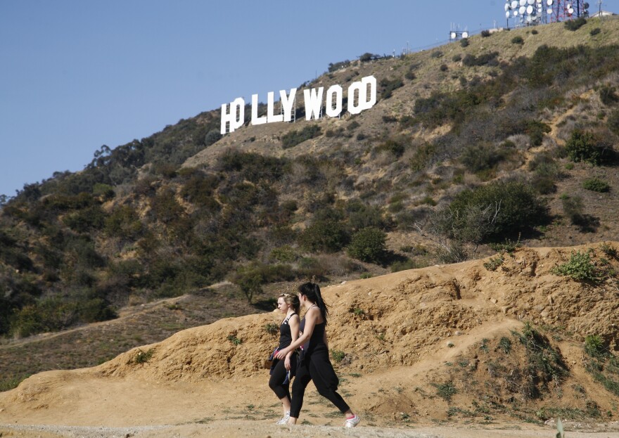 Two unidentified women hike in Griffith Park near the Hollywood sign after a plastic bag containing a human head was discovered Tuesday by two women walking their dogs on a nearby trail off Canyon Drive.