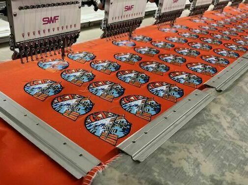 Machines at A-B Emblem stitch a NASA patch for the International Space Station's Expedition 67 Mission.