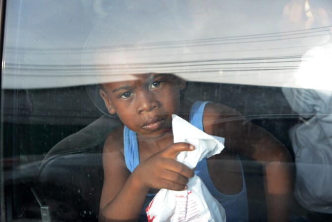 A young boy looks out of a car window upon arriving to San Pedro Sula, 240 kms north of Tegucigalpa, on July 2, 2014, after being deported from the US. Thousands of unaccompanied children, most of them from Central America, have trekked to the United States in recent months and now face deportation in what the United States has called a humanitarian crisis. 