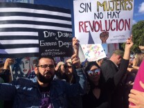 Attendees at the Women's March of Los Angeles hold signs in the streets of Downtown L.A.