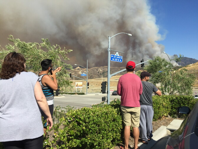 Locals watch the progress of the Sand Fire from a Target parking lot in Santa Clarita on Sunday, July 24, 2016.