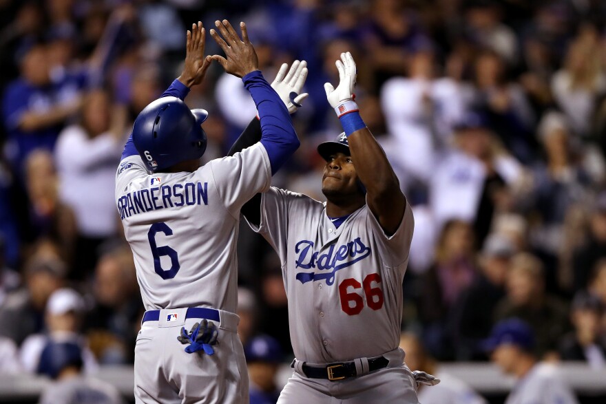DENVER, CO - SEPTEMBER 30:  Yasiel Puig #66 of the Los Angeles Dodgers is congratulated by Curtis Granderson #6 after hitting a 2 RBI home run in the fifth inning against the Coloarado Rockies at Coors Field on September 30, 2017 in Denver, Colorado.  (Photo by Matthew Stockman/Getty Images)