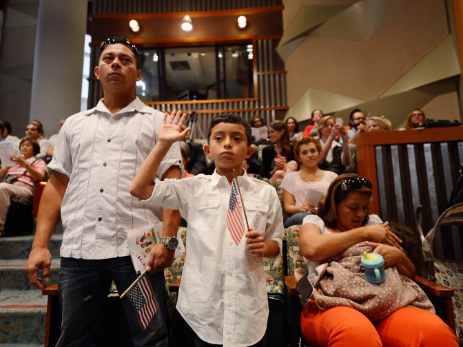 U.S. citizenship candidate Ricardo Barrera, 8, takes the oath of citizenship as his father Ricardo Barrera (L) mother Reina Barrera and his sister Ashley, 1, look on during a naturalization ceremony at the Los Angeles Central Library on September 19, 2012 in Los Angeles, California. Fifty local children participated in the citizenship ceremony. In recognition of Constitution Day and Citizenship Day, over 32,000 new citizens will be welcomed by U.S. Citizenship and Immigration Services from September 14 to September 22.  