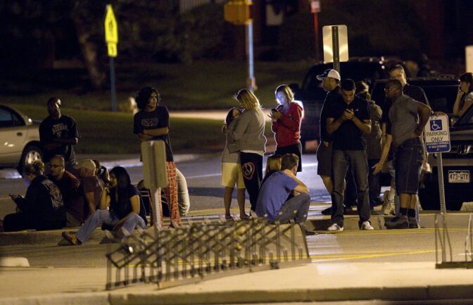 Family and friends wait outside Gateway High School where witnesses were brought for questioning after a shooting at a movie theater showing the Batman movie "The Dark Knight Rises," Friday, July 20, 2012 in Aurora, Colo.  A gunman wearing a gas mask set off an unknown gas and fired into the crowded movie theater killing 12 people and injuring at least 50 others, authorities said. (AP Photo/Barry Gutierrez)