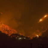 CARPINTERIA, CA - DECEMBER 10: Flames come close to a house as the Thomas Fire advances toward Santa Barbara County seaside communities on December 10, 2017 in Carpinteria, California. The Thomas Fire has grown to 173,000 acres and destroyed at least 754 structures so far. Strong Santa Ana winds have been feeding major wildfires all week, destroying houses and forcing tens of thousands of people to evacuate.  (Photo by David McNew/Getty Images)