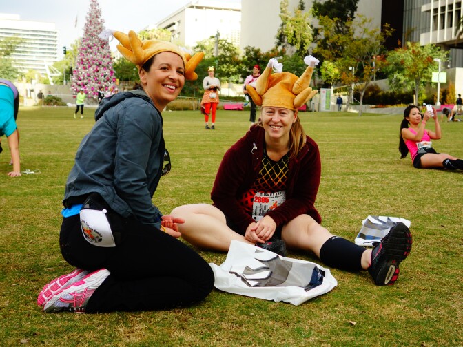 Veronica Velasco of Duarte and Jill Sczech of Rancho Cucamonga relax before running the 10K distance of the Turkey Trot LA Thanksgiving-themed race Nov. 28, 2013 in Downtown L.A.