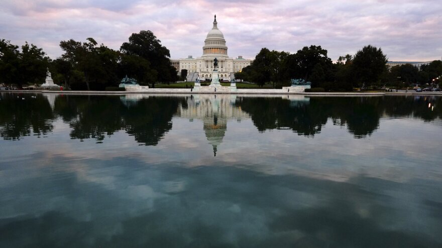 The Capitol is mirrored in its reflecting pool early Tuesday, Oct. 1, 2013, as the partial federal shutdown began. But there's a battle still to come in which the stakes are even higher.

