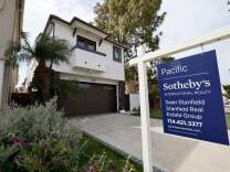 A home for sale sign in front of a house in Huntington Beach.   (Allen J. Schaben / Los Angeles Times via Getty Images)