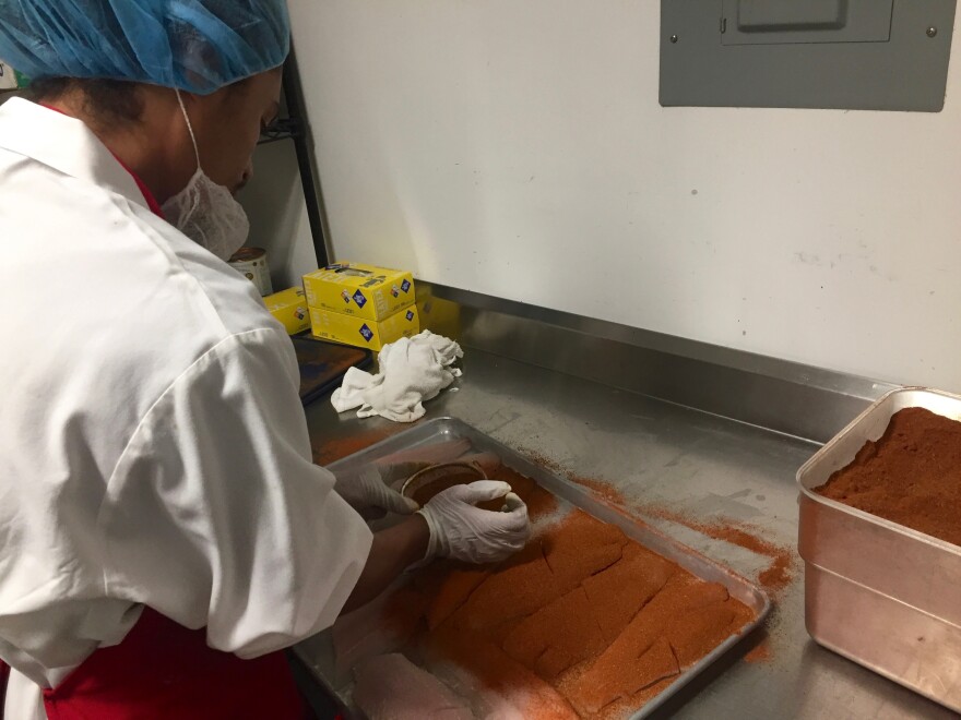 Everytable cook Andres Chopin works in the commercial kitchen, seasoning fish that will later be added to one of the chain’s pre-packaged meals.