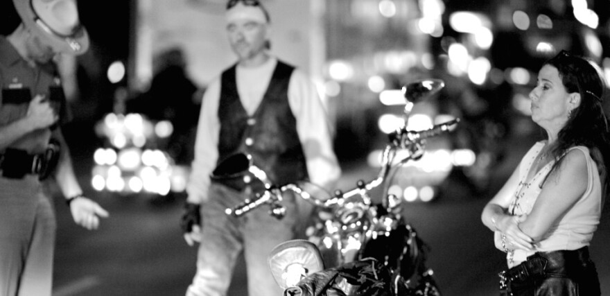 A cyclist performs a field sobriety test near the site of the Sturgis Motorcycle Rally